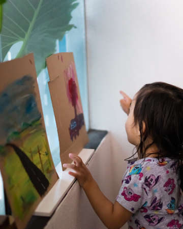 Bangi, Malaysia - Mar 27, 2020: Cute asian toddler happy and exited looking at the paintings.のeditorial素材