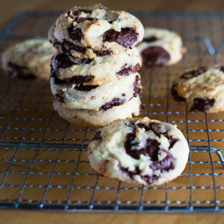 Homemade baked chocolate chip soft cookies cooling on a cooling rack. On a wooden background....