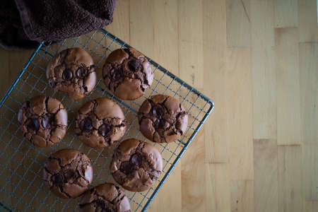 soft dark chocolate brownie cookies on a metal rack on a wooden background.