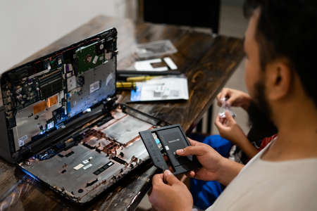 Bangi, Malaysia - May 15, 2020: Changing the Hard drive with cd rom inside laptop at home. DIY project at home. Life skill for everyone.のeditorial素材