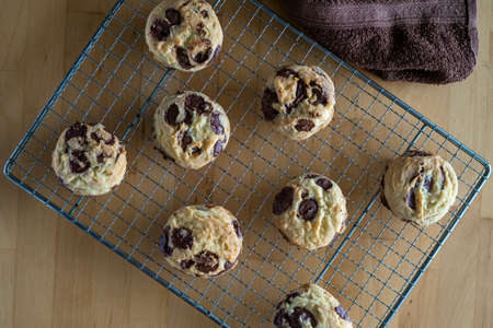 Homemade baked chocolate chip soft cookies cooling on a cooling rack. On a wooden background....