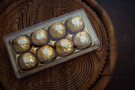 Kuala Lumpur, Malaysia - May 16, 2020: Ferrero Rocher premium chocolate sweets on wooden background. Luxury taste.のeditorial素材