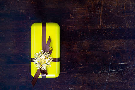 Yellow gift boxes with golden brooch. Traditional songket on one of the boxes. Unique luxury...