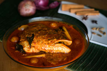 Malaysian traditional dish, fish head curry served on banana leaf with various ingredients spices . Selective focus.の写真素材