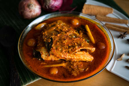 Malaysian traditional dish, fish head curry served on banana leaf with various ingredients spices . Selective focus.の写真素材