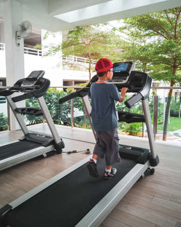 preteen child is training on treadmill  in fitness studio, gym class kids conceptの写真素材