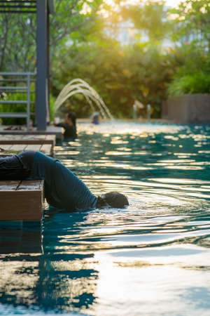 Young boy kid child dive head into water playing at the swimming pool. Funny, weird and playful kid concept.の写真素材