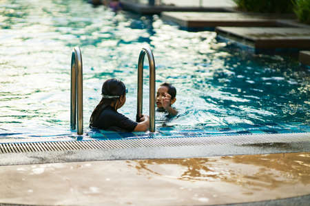 Asian children swimming at the swimming pool.