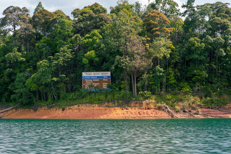 Kenyir, Malaysia - July 23, 2020: Direction signboard on a small island in Kenyir Lake, Malaysia....