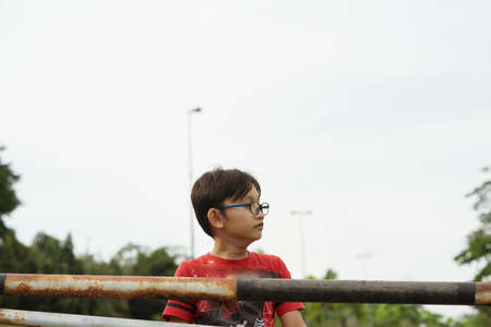 A portrait of young malay boy wearing glasses outdoor.の写真素材