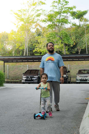 Asian father and daughter walking  and playing on the road at the day time. People having fun...