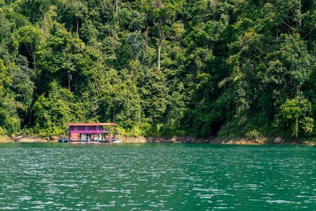Kenyir, Malaysia - July 23, 2020: Houseboat crusing through the lake with mountain view at Kenyir Lake. Tasik Kenyir is a man made lake.のeditorial素材
