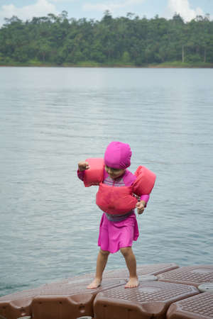 Closeup portrait of cute little girl swimming, happy child having fun in water, beach resort, summer vacation and holidays conceptの写真素材
