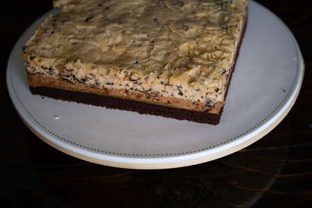 Three layer white  chocolate mousse cake on a white plate.