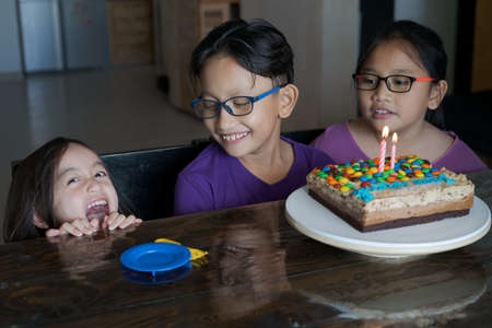 Happy family with three sibling celebrating birthday in quarantine time, self-isolation and family...
