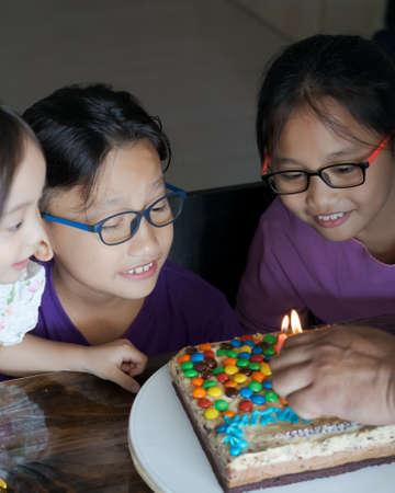 Happy family with three sibling celebrating birthday in quarantine time, self-isolation and family...