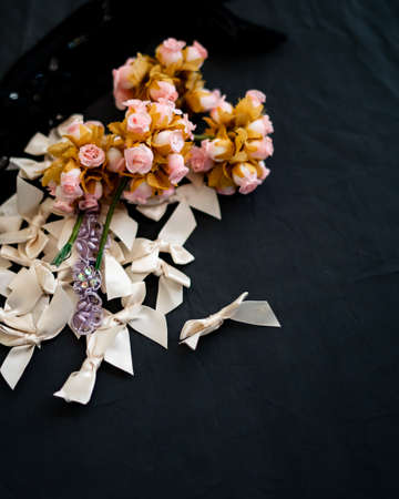 Flat lay top view of spring flowers, ribbons on a black background.の写真素材