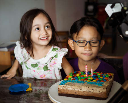Kuala Lumpur, Malaysia - August 8, 2020: Colourful birthday cake with candle with a boy and his...