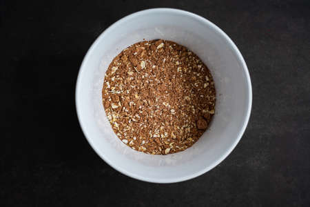 breakfast of healthy banana flakes with chocolate, oat, granola in a white bowl.の写真素材
