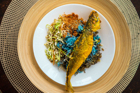 Nasi kerabu is a Malay rice dish, a type of nasi ulam, in blue-coloured and eaten either with fried...