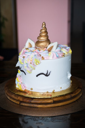 A beautiful bright colourful and white cake decorated in the form of fantasy unicorn. The concept of a festive dessert for kids birthdayの写真素材