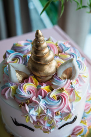 A beautiful bright colourful and white cake decorated in the form of fantasy unicorn. The concept of a festive dessert for kids birthdayの写真素材