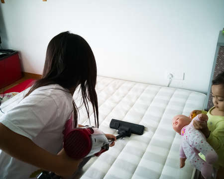 Cleaning the mattress with vacuum cleaner at home.の写真素材