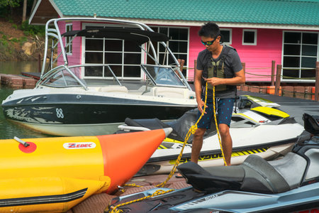 Kenyir, Malaysia July 24, 2020 : Boatman standing amont the jetski, speed boat and banana boat at the Kenyir Eco Resort.のeditorial素材