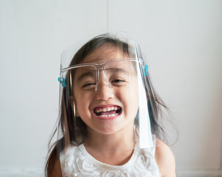 A cute toddler girl wearing the face protection shield.の写真素材