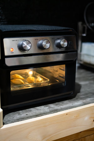 Air fryer oven is cooking food in the kitchen.の写真素材