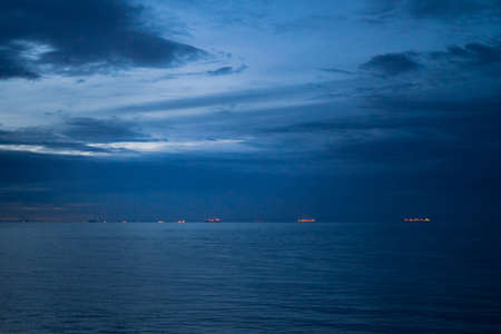 blue sunset sky over sea. intense colors. Twilight landscape. Sun at dusk. The image contain soft focus, noise and grain.の写真素材