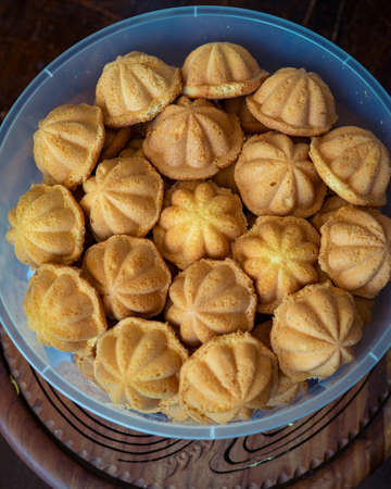Kuih Bahulu, baulu or bolu in a container. Sponge cake baked in special aluminium moulds is the...