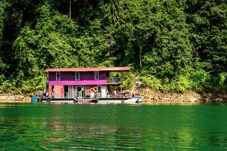 Kenyir, Malaysia - July 23, 2020: Houseboat crusing through the lake with mountain view at Kenyir Lake. Tasik Kenyir is a man made lake.のeditorial素材