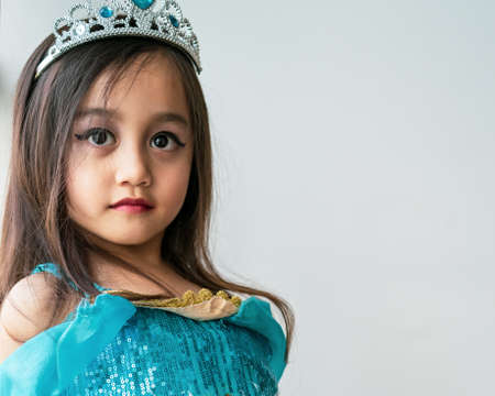Portrait of a child girl dressed in arabian princess costume against white background. Natural light, selective focus.の写真素材