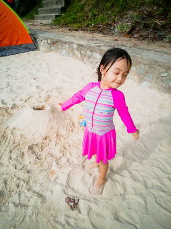 Little asian girl playing on the beach. Vacation and relaxing concept.の写真素材
