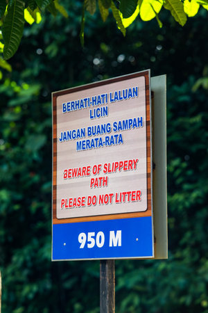 Beware of slippery path, please do not litter and berhati - hati laluan licin, jangan buang sampah merata - rata signboard at the 950m height.のeditorial素材