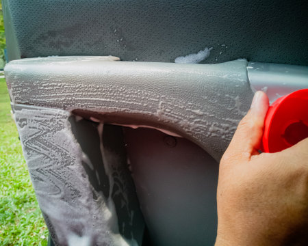 Dry cleaning the car interior with special foam. Car care concept. Car detailing. Cleaning driver seat using professional tools and cleanersの写真素材