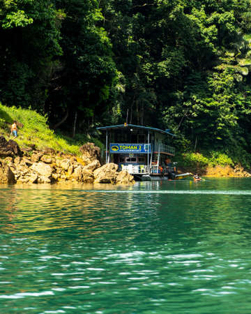 Kenyir, Malaysia - July 23, 2020: Houseboat crusing through the lake with mountain view at Kenyir Lake. Tasik Kenyir is a man made lake.のeditorial素材