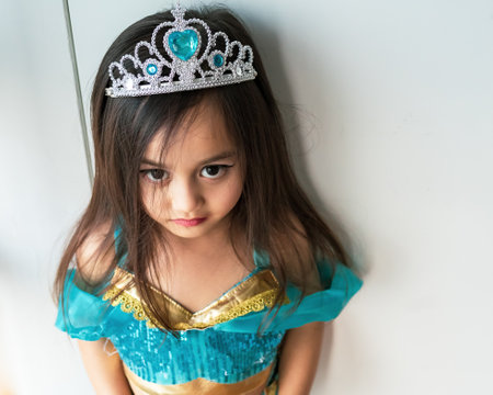 Portrait of a child girl dressed in arabian princess costume against white background. Natural light, selective focus.の写真素材