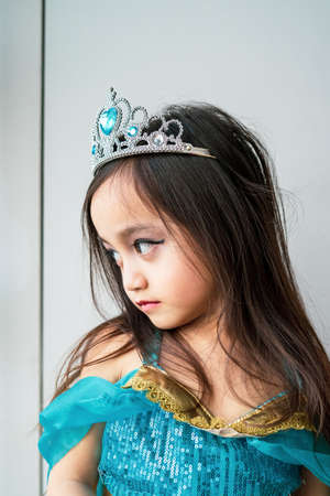 Portrait of a child girl dressed in arabian princess costume against white background. Natural light, selective focus.の写真素材