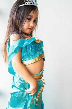 Portrait of a child girl dressed in arabian princess costume against white background. Natural...