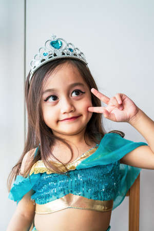 Portrait of a child girl dressed in arabian princess costume against white background. Natural light, selective focus.の写真素材