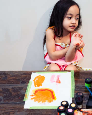 Cute little Asian girl painting a picture in home studioの写真素材