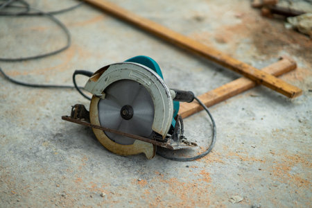 portable circular saw tool with long wires to cut wood in a construction site.の写真素材