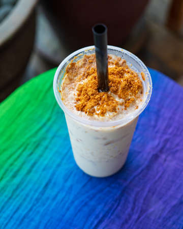 Iced blended caramel coffee topped with crushed caramel biscoff in plastic glass. Hot season...