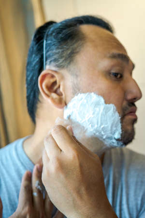 Asian man hand implies of shaving beard with razor.の写真素材