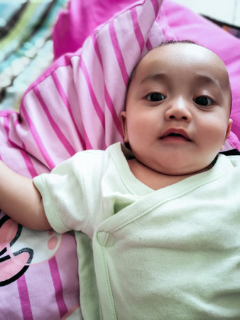 Cute small girl lying at bed. Childhood concept. Serious child. Stay home.の写真素材