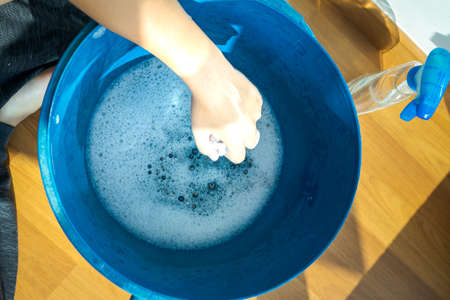 High angle view of bucket containing soap sud with hand milking rags. Cleaning home in the morning.