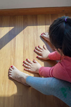 Hands and feet with henna in a bright sunlight on the floor. Drying henna at home.