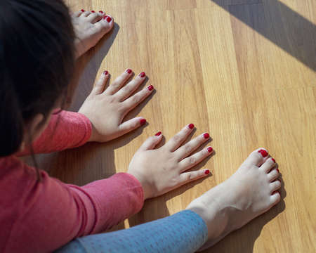 Hands and feet with henna in a bright sunlight on the floor. Drying henna at home.の写真素材